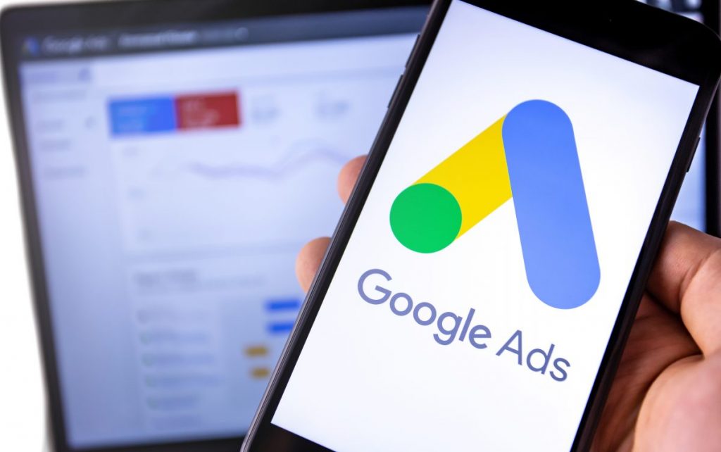 personne tenant un téléphone en main avec le logo de google ads